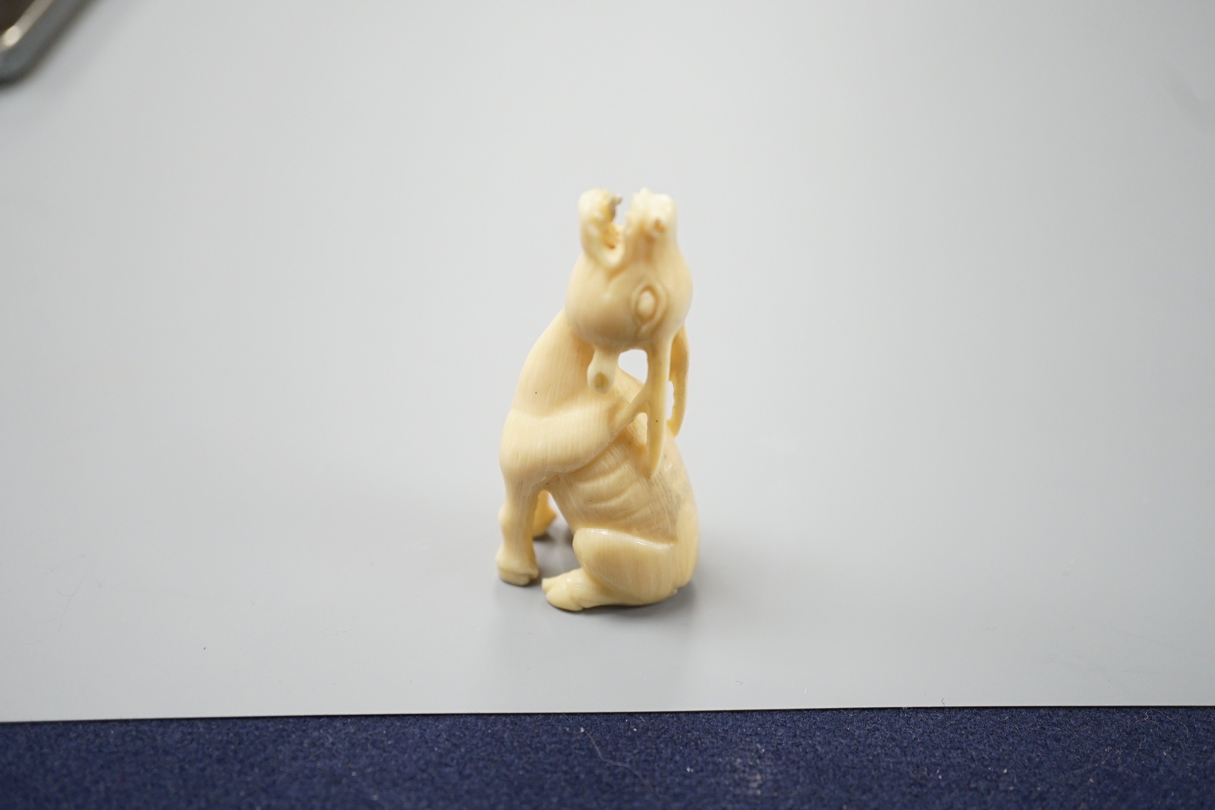A Japanese ivory netsuke of a seated bellowing deer, 19th century, bears signature, 5.8cm